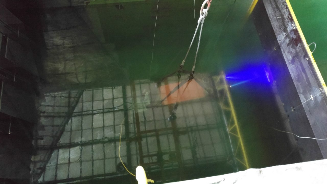 Looking into the test pool — submarine robot suspended by crane.